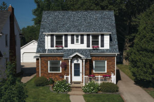 The front on an updated two-story home with brick siding and a gray asphalt shingle roof.