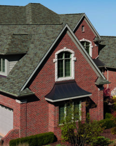 Large home with brick exterior walls and newly replaced roof.