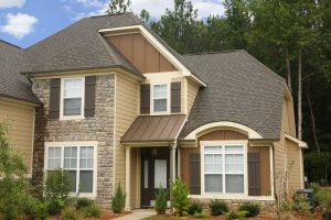 A beautiful view of a home with beige siding and a brown roof