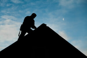 Contractor working on a Roof Top with blue Sky in Background