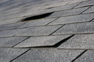 Close view of a damaged roof top that needs repair.