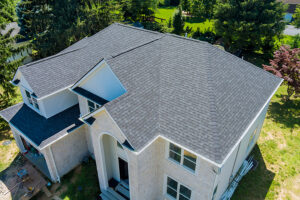 Aerial view of a house roof with new asphalt shingles construction