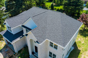 Aerial view of asphalt shingles construction site roofing the house with new window