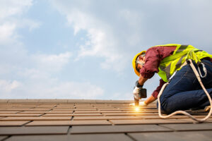 Construction worker wearing hardhat installing new roof